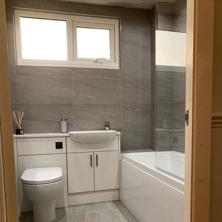 Family bathroom with fitted vanity unit by JWA Building Services