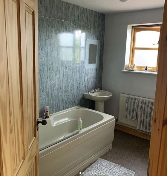 Bathroom with bath and pedestal basin by JWA Building Services