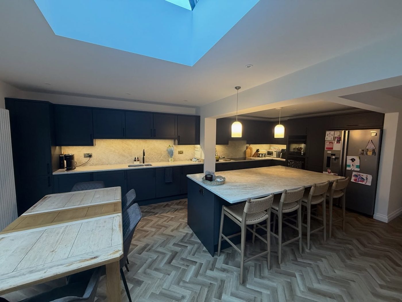 Navy open-plan kitchen with island by JWA Building Services