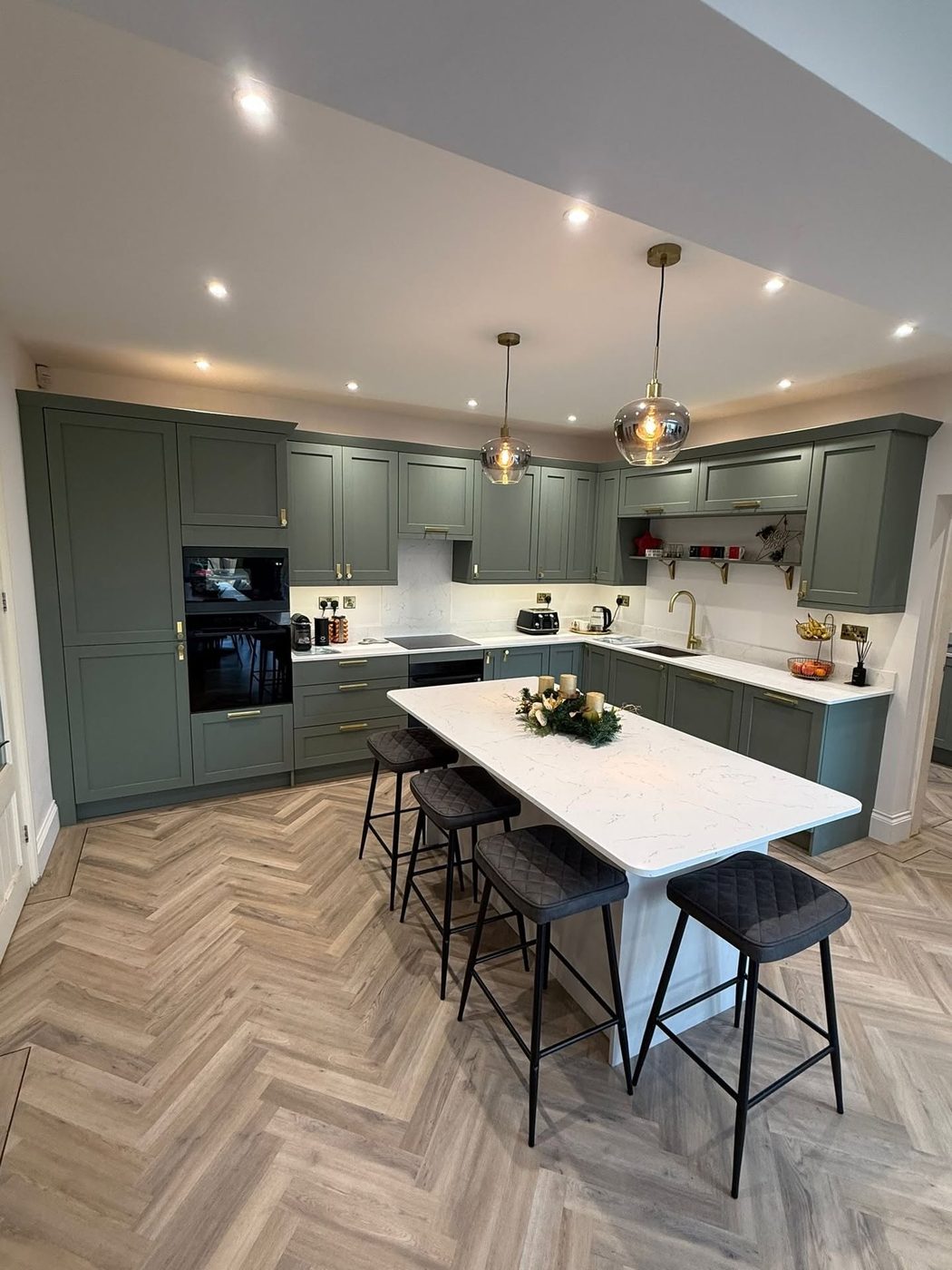Sage green kitchen with island by JWA Building Services